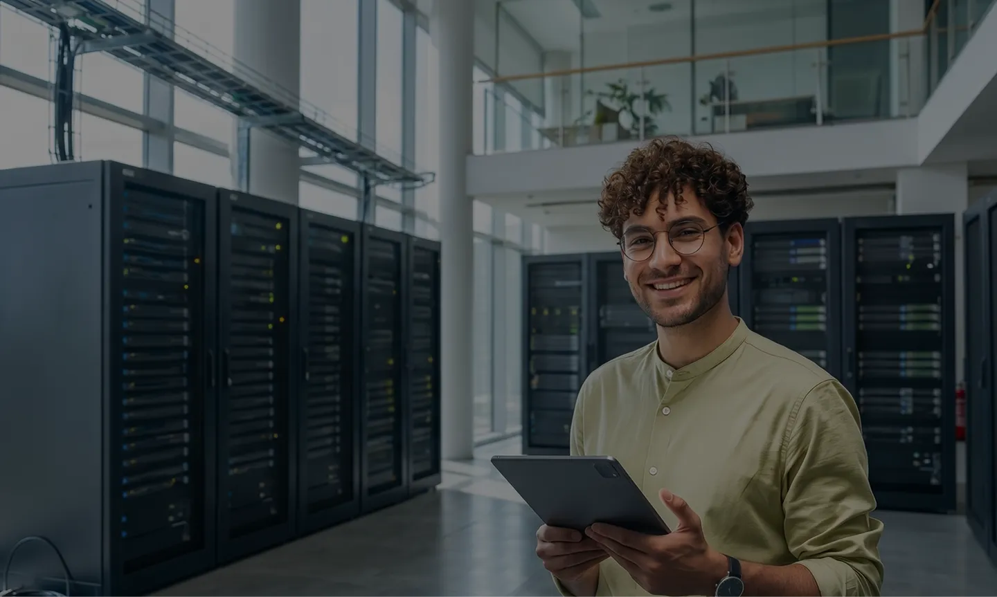 IT specialist holding a tablet in a modern data centre server room